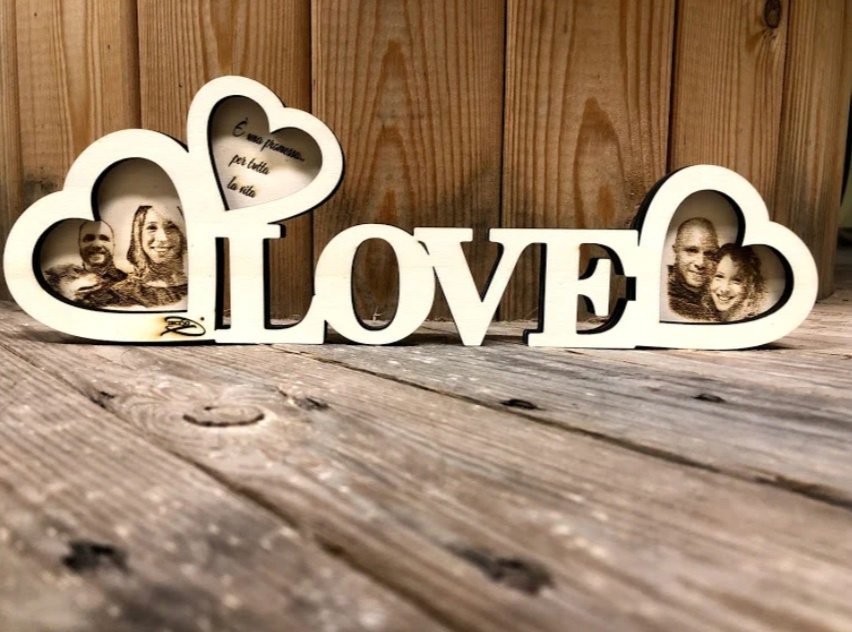 Scritta LOVE in legno con cuori alle estremità, con foto incise all'interno dei cuori