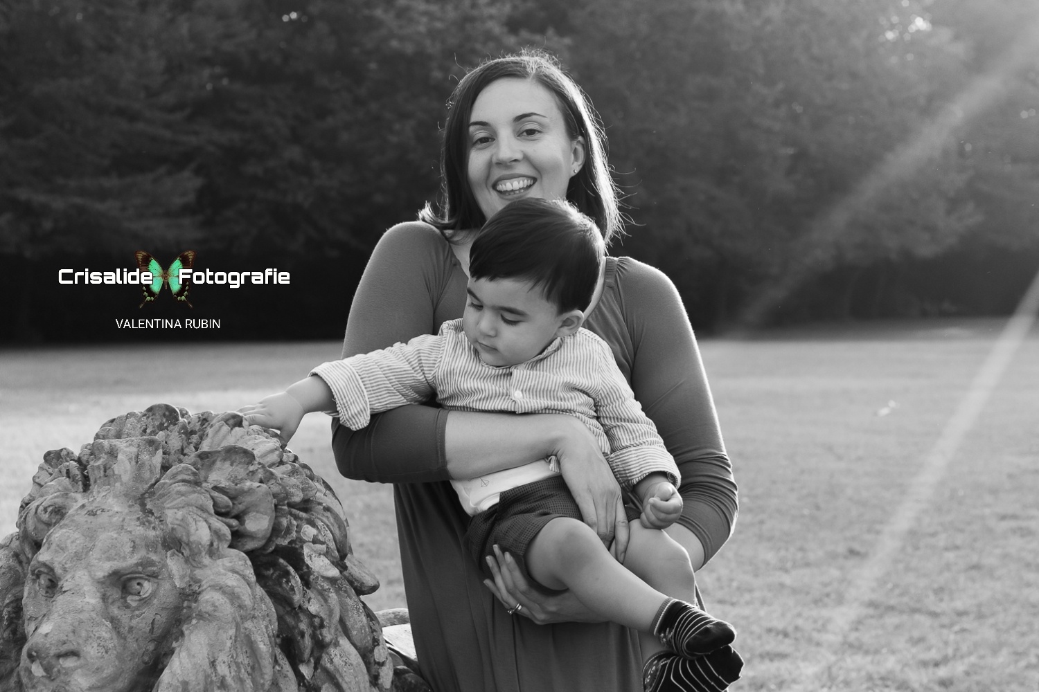 Mamma sorridente abbraccia il suo bambino al parco di Villa Belvedere a Mirano, Venezia; servizio fotografico di famiglia in stile naturale e in bianco e nero