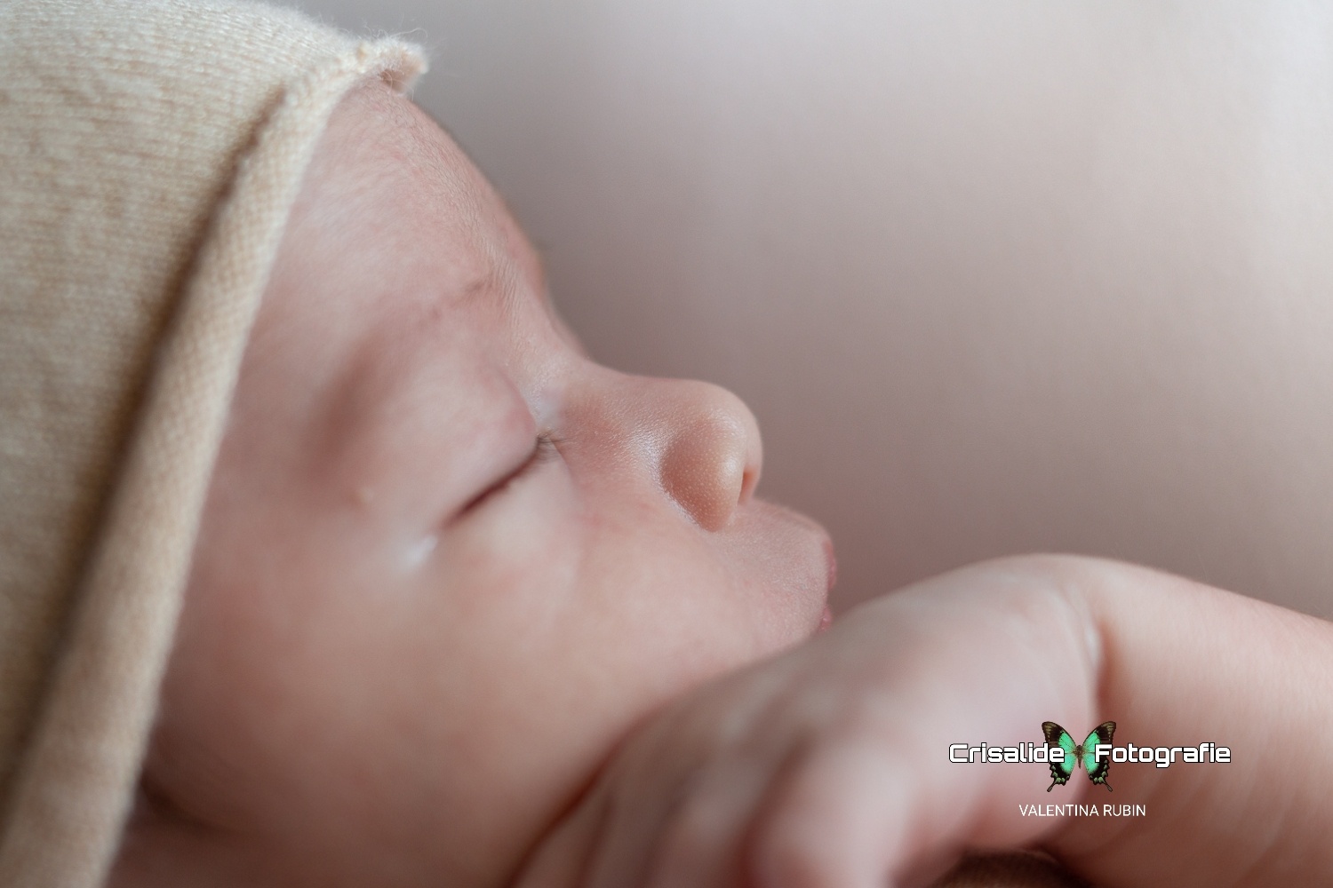 Neonato che dorme, di profilo, in primo piano il nasino e occhi