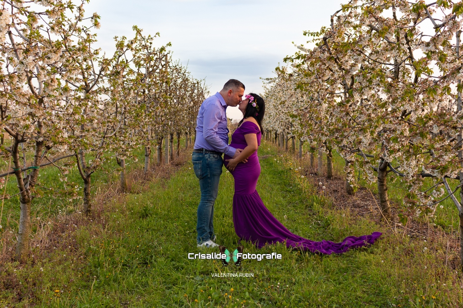 Coppia che si bacia tra alberi in fiore con fiori bianchi in primavera