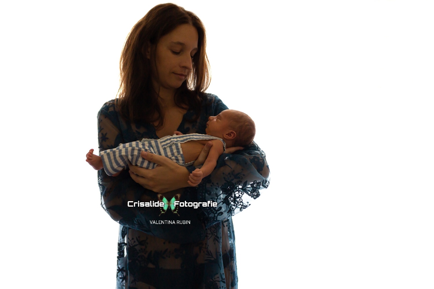 Mamma in abito blu in pizzo che guarda il neonato addormentato tra le sue braccia, su sfondo bianco