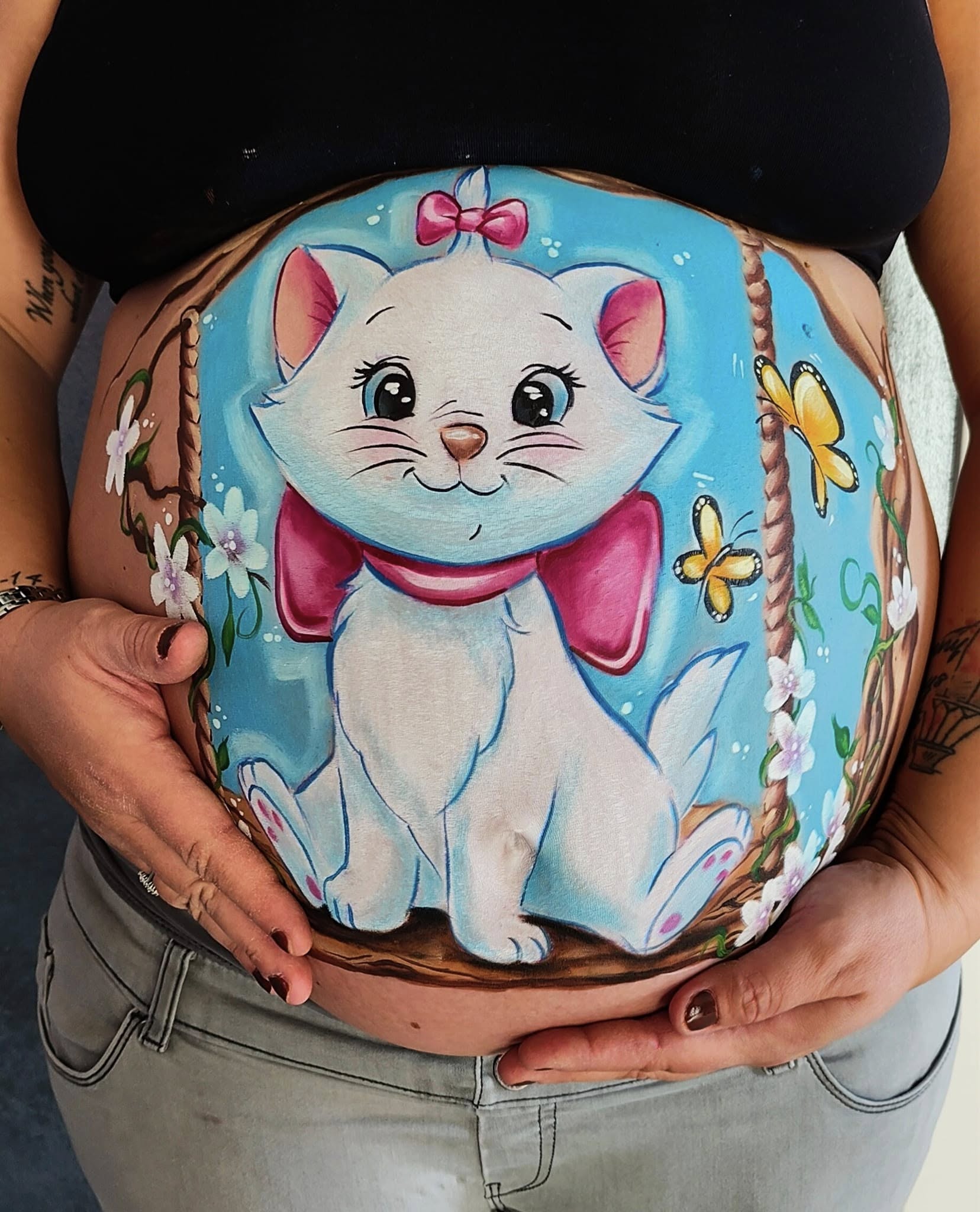 Primo piano del pancione di una mamma incinta con belly painting colorato con gattina