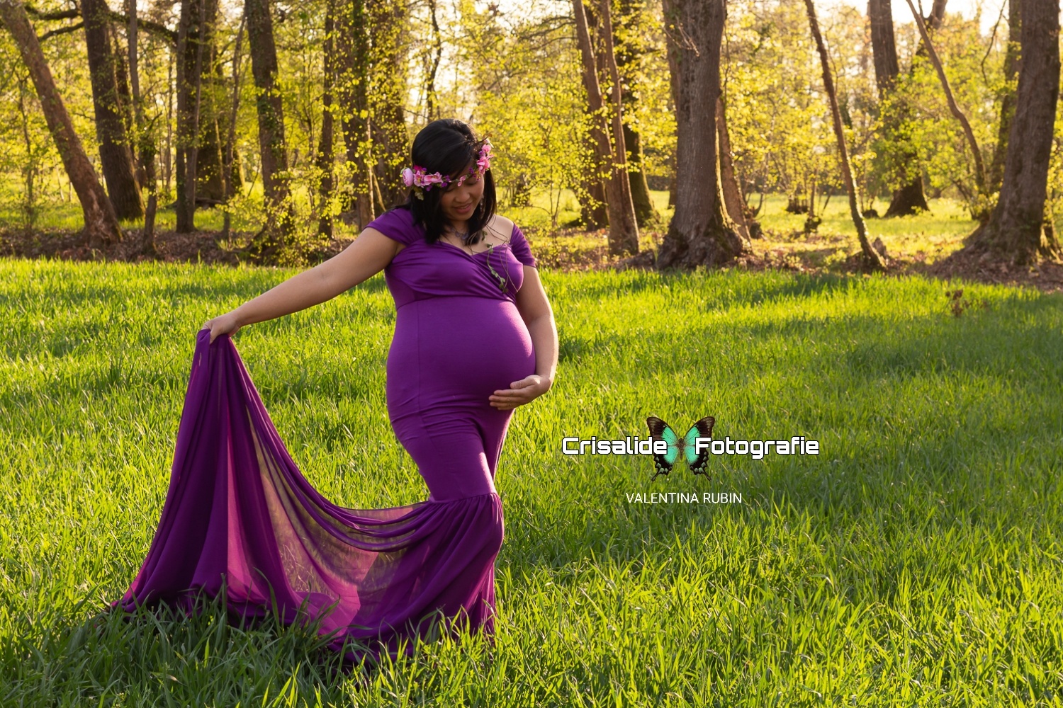 Mamma incinta, con abito viola a sirena, in mezzo alla natura