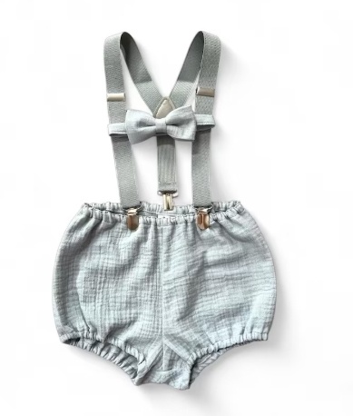 Abito bimbo azzurro, pantaloncini, con bretelle e papillon coordinato. Sfondo bianco